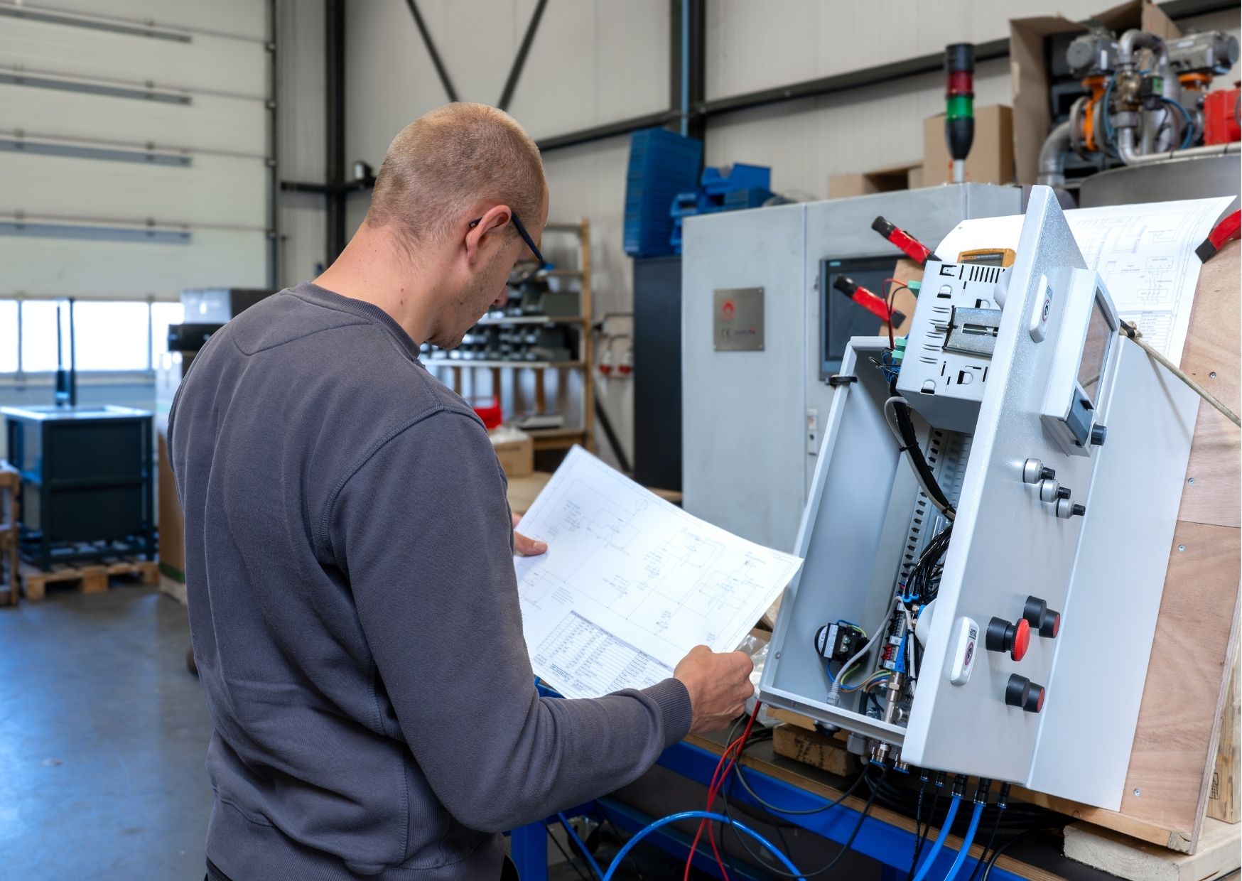 Elektromonteur bij HBF Techniek in Rijssen bekijkt een elektrisch schema tijdens werkzaamheden aan een besturingskast.